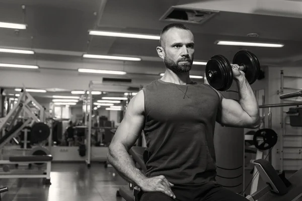 El hombre hace ejercicios para bíceps en el gimnasio . — Foto de Stock
