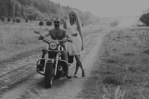 Casal motociclista foto preto e branco em uma motocicleta no campo. Fotografia de amor apaixonado transferido. Acessórios bonitos e motocicleta. Foto para motocicleta — Fotografia de Stock