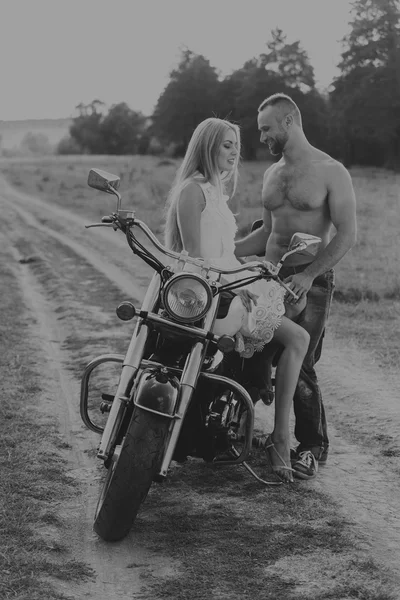 Casal motociclista foto preto e branco em uma motocicleta no campo. Fotografia de amor apaixonado transferido. Acessórios bonitos e motocicleta. Foto para motocicleta — Fotografia de Stock