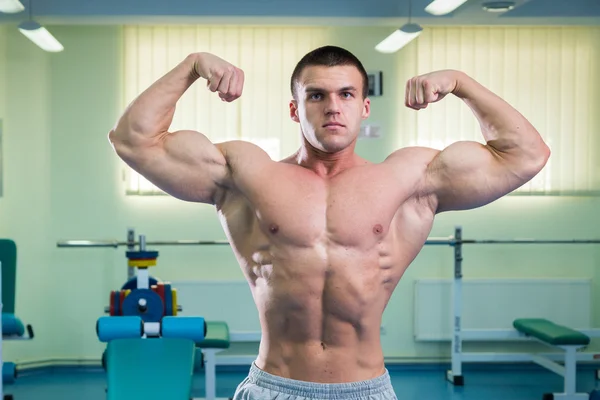 Όμορφος, αθλητικό, αυτοπεποίθηση ο άνθρωπος στο γυμναστήριο. bodybuilding πόζα — Φωτογραφία Αρχείου