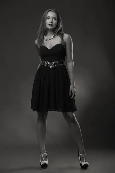 Kusząca brunetka w piękny stylowy sukienka na ciemnym tle. — Zdjęcie stockowe