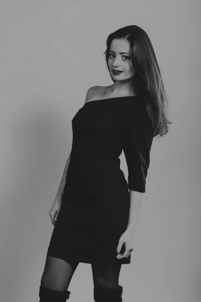 Charmante Brünette in stilvollem Kleid auf dunklem Hintergrund. — Stockfoto