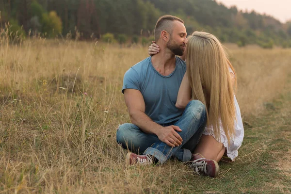 Unga par på ett fält — Stockfoto