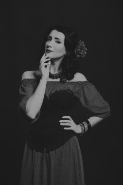 Karanlık bir arka plan üzerinde güzel, gizemli, şirin esmer. Siyah ve beyaz fotoğraf güzel gizemli esmer.