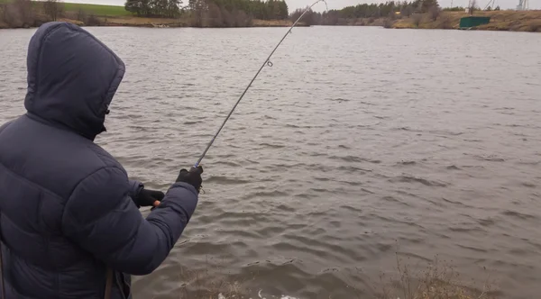 Man med spinning på sjön. Fiske — Stockfoto