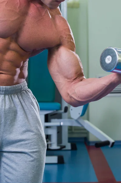 Atleet in de sportschool maken van verticale lijnen. De bevoegdheid tot het uitoefenen van de spieren van de rug. Foto's voor sportieve tijdschriften, posters en websites. — Stockfoto