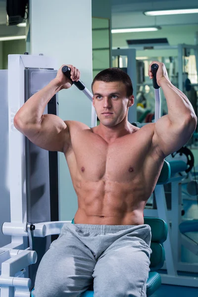 Atleta en el gimnasio haciendo empuje vertical. El poder de ejercitar los músculos de la espalda. Fotos para revistas deportivas, carteles y sitios web . — Foto de Stock