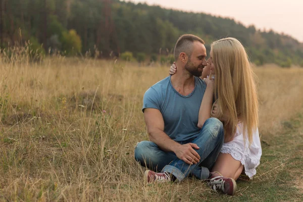 Young couple in a field — Stock Photo, Image