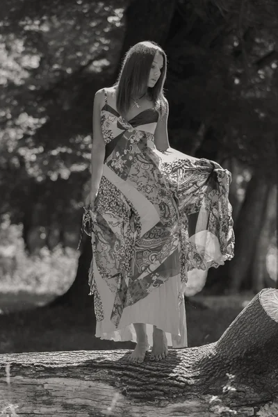 Junge brünette Frau in einem weißen Kleid. Ein Mädchen steht an einem sonnigen Tag inmitten eines rosafarbenen Blumenfeldes. Feld, Blumen Schönheit, Natur - das Konzept des Landurlaubs. Artikel über Urlaub. — Stockfoto