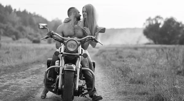 Ένα νεαρό ζευγάρι στην αγάπη σε μια μοτοσικλέτα σε ένα πεδίο — Φωτογραφία Αρχείου