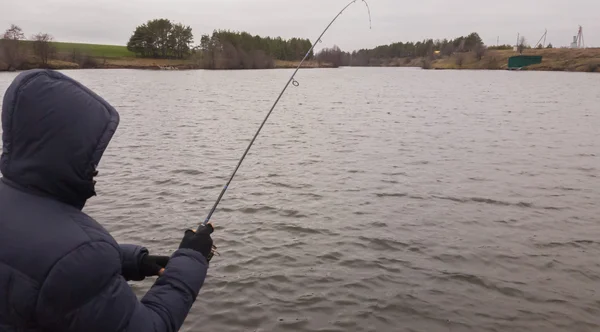 Man med spinning på sjön. Fiske — Stockfoto