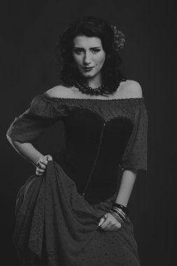 Karanlık bir arka plan üzerinde güzel, gizemli, şirin esmer. Siyah ve beyaz fotoğraf güzel gizemli esmer.