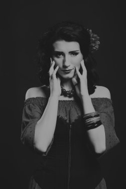 Karanlık bir arka plan üzerinde güzel, gizemli, şirin esmer. Siyah ve beyaz fotoğraf güzel gizemli esmer.