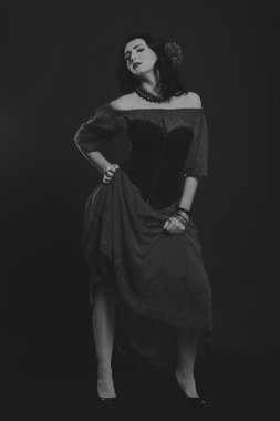 Karanlık bir arka plan üzerinde güzel, gizemli, şirin esmer. Siyah ve beyaz fotoğraf güzel gizemli esmer.