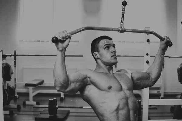 A very strong man is engaged in the gym — Stock Photo, Image