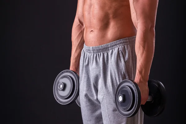 Bodybuilder poseren in verschillende poses aan te tonen hun spieren. Storing op een donkere achtergrond. Mannelijke weergegeven: spieren spannen. Mooi gespierd lichaam atleet. — Stockfoto