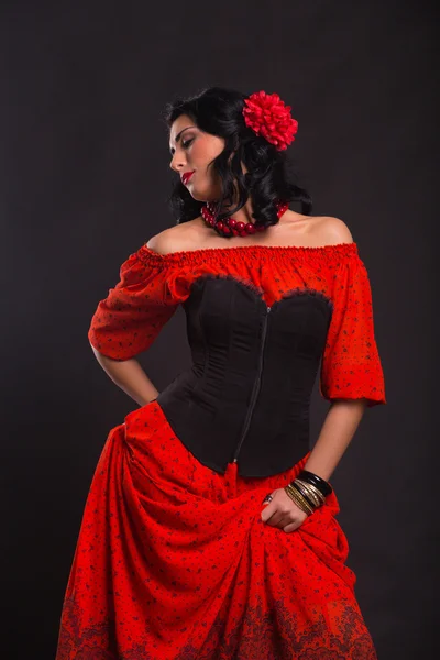 Belle femme dans une robe rouge dansant sur un fond noir — Photo