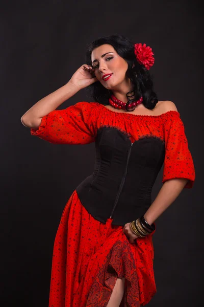 Hermosa mujer en un vestido rojo bailando sobre un fondo negro —  Fotos de Stock