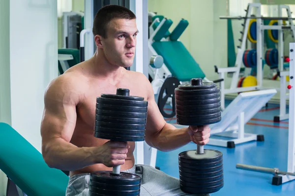 Un hombre fuerte. Entrenamiento muscular en el gimnasio. Entrenamiento en el gimnasio . — Foto de Stock