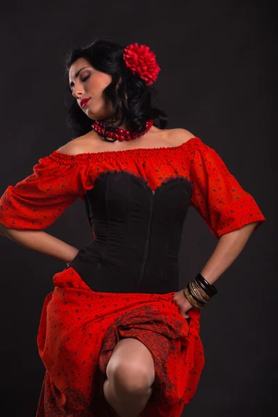 Bella donna in un abito rosso che balla su uno sfondo nero — Foto Stock