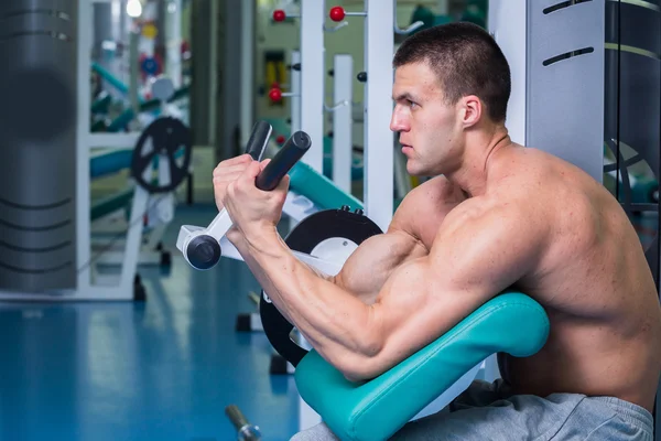 Un hombre fuerte. Entrenamiento muscular en el gimnasio. Entrenamiento en el gimnasio . — Foto de Stock