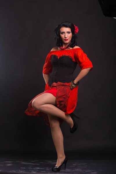 Belle femme dans une robe rouge dansant sur un fond noir — Photo