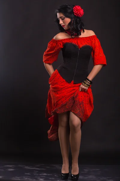 Mulher bonita em um vestido vermelho dançando em um fundo preto — Fotografia de Stock