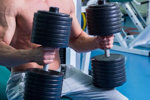 Un hombre fuerte. Entrenamiento muscular en el gimnasio. Entrenamiento en el gimnasio . —  Fotos de Stock