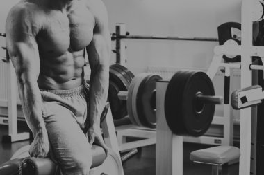 Jimnastik salonu kas adam. Kol kasları üzerinde çalışıyorum. Eğitim bir simülatör. Yorucu iş onun vücudunda.