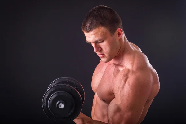 Bodybuilder poseren in verschillende poses aan te tonen hun spieren. Storing op een donkere achtergrond. Mannelijke weergegeven: spieren spannen. Mooi gespierd lichaam atleet. — Stockfoto