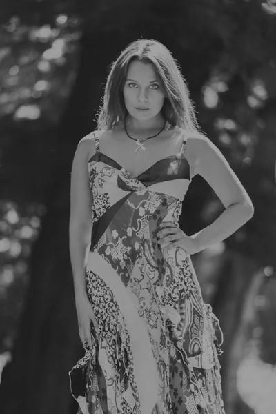 Mujer morena joven en un vestido blanco. Una chica está parada en medio del campo de flores rosadas en un día soleado. Campo, flores belleza, naturaleza, - El concepto de vacaciones en el campo. Artículo sobre vacaciones . —  Fotos de Stock