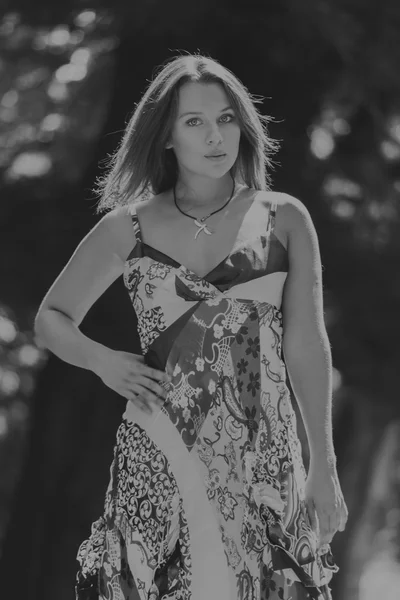 Mujer morena joven en un vestido blanco. Una chica está parada en medio del campo de flores rosadas en un día soleado. Campo, flores belleza, naturaleza, - El concepto de vacaciones en el campo. Artículo sobre vacaciones . —  Fotos de Stock