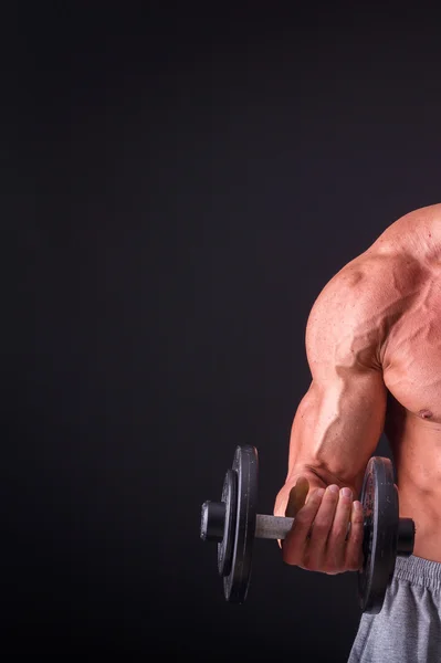 Fisiculturista posando em diferentes poses demonstrando seus músculos. Falha num fundo escuro. Homem mostrando músculos se esforçando. Bonito atleta corpo muscular . — Fotografia de Stock