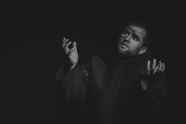 Beautiful and fascinating game theater actor on camera. Black and white photo of the actor in the guise of a beggar on a dark background. Beautifully decorated stage image and professional makeup.