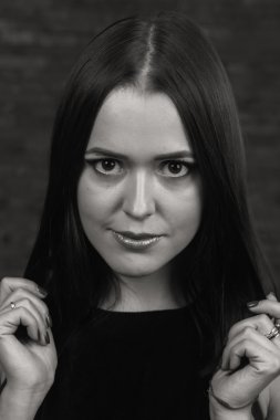 Karanlık bir arka plan üzerinde güzel, gizemli, şirin esmer. Siyah ve beyaz fotoğraf güzel gizemli esmer.