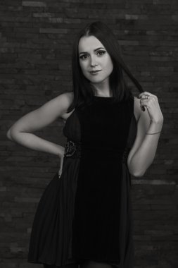 Karanlık bir arka plan üzerinde güzel, gizemli, şirin esmer. Siyah ve beyaz fotoğraf güzel gizemli esmer.