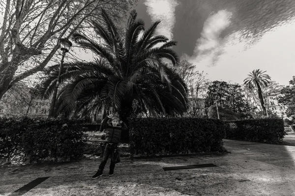 Chlapec pěti procházky v parku. Boy v parku s palmami — Stock fotografie