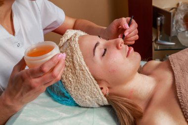 Güzellik bakımları için sorun cilt. Krem uygulamak kız spa salonda.