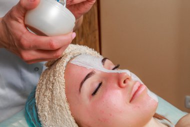 Güzellik bakımları için sorun cilt. Krem uygulamak kız spa salonda.