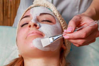 Güzellik bakımları için sorun cilt. Krem uygulamak kız spa salonda.