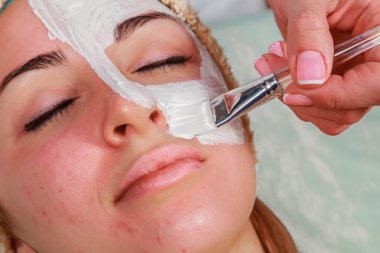 Güzellik bakımları için sorun cilt. Krem uygulamak kız spa salonda.