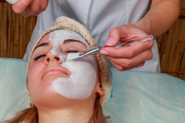 Güzellik bakımları için sorun cilt. Krem uygulamak kız spa salonda.