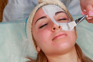 Güzellik bakımları için sorun cilt. Krem uygulamak kız spa salonda.