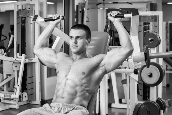 Atleta en el gimnasio haciendo empuje vertical. El poder de ejercitar los músculos de la espalda. Fotos para revistas deportivas, carteles y sitios web . —  Fotos de Stock