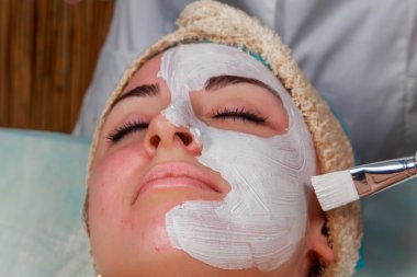 Güzellik bakımları için sorun cilt. Krem uygulamak kız spa salonda.