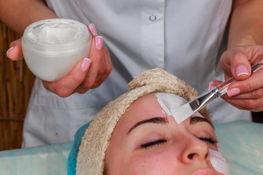 Güzellik bakımları için sorun cilt. Krem uygulamak kız spa salonda.
