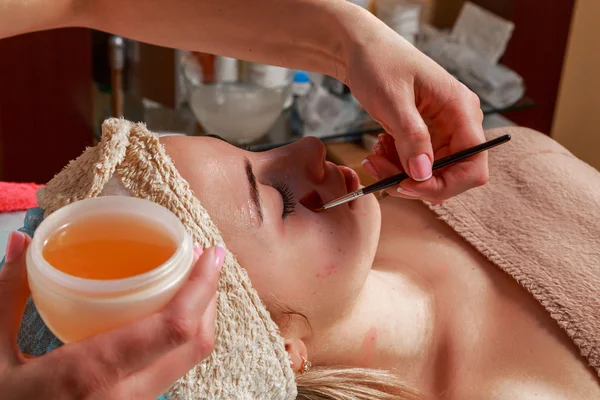 Beauty treatments for problem skin. The girl in the spa salon, applying cream. — Stock Photo, Image