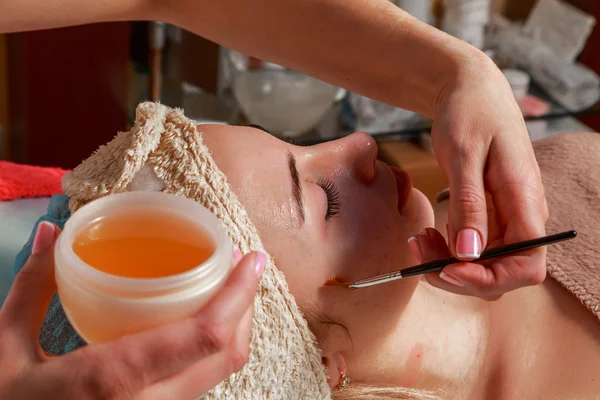 Tratamentos de beleza para a pele problema. A menina no salão de spa, aplicando creme . — Fotografia de Stock