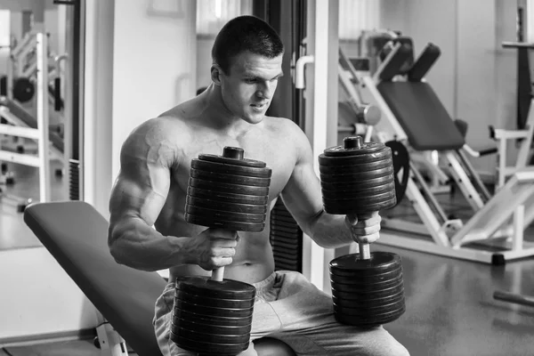 Un hombre fuerte. Entrenamiento muscular en el gimnasio. Entrenamiento en el gimnasio . — Foto de Stock