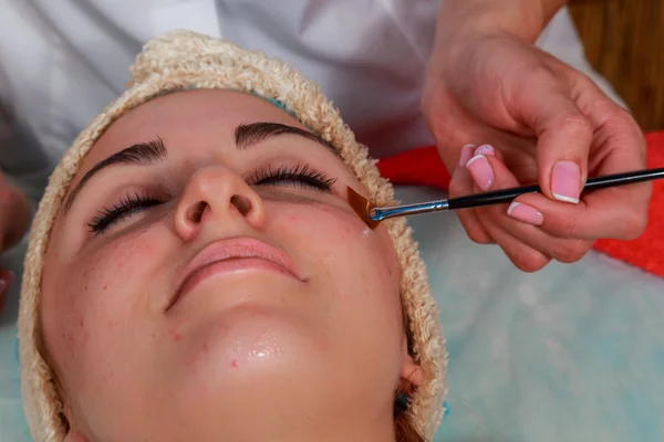 Tratamentos de beleza para a pele problema. A menina no salão de spa, aplicando creme . — Fotografia de Stock